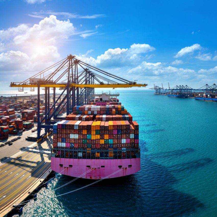 Aerial view of cargo ship and cargo container in harbor.